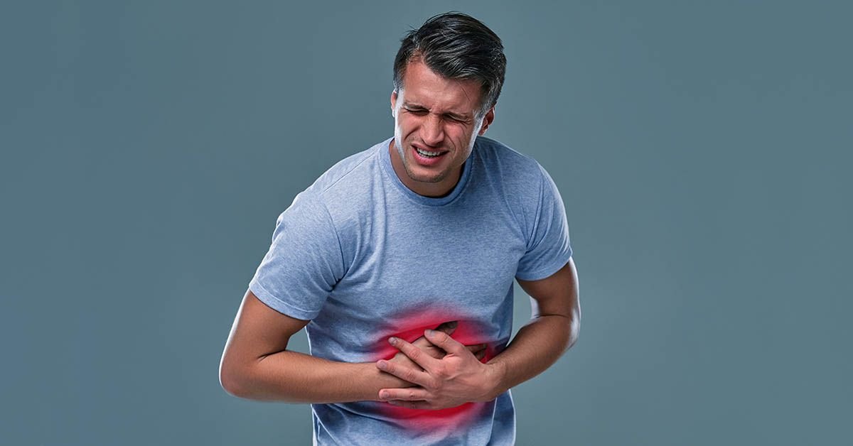 Hombre tocandose en la zona de la hernia con dolor